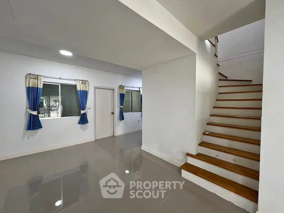 Spacious modern interior with sleek staircase and large windows, perfect for family living.