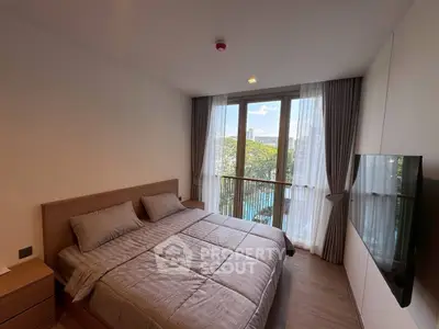 Modern bedroom with large window and balcony view in luxury apartment