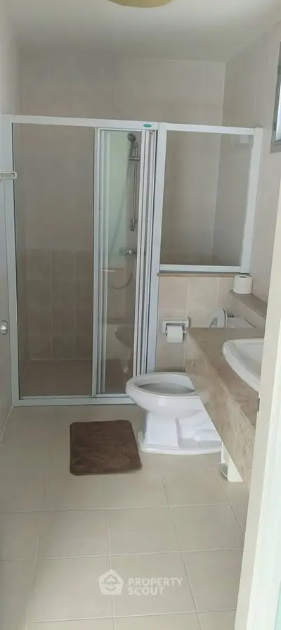 Modern bathroom with glass shower enclosure and sleek fixtures