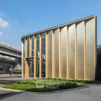 Modern architectural building with sleek design and golden facade, ideal for commercial real estate investment.