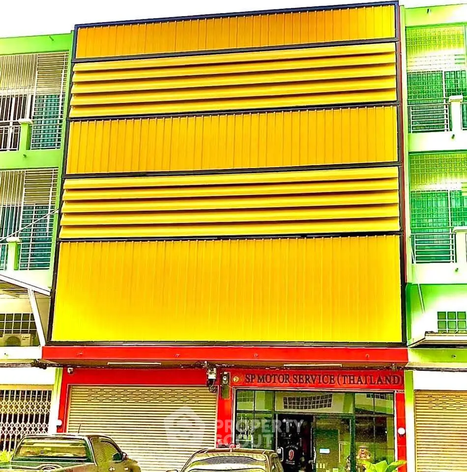 Vibrant commercial building exterior with bold yellow facade and modern design in urban setting.