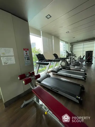 Modern gym with treadmills and exercise equipment in a high-rise building.