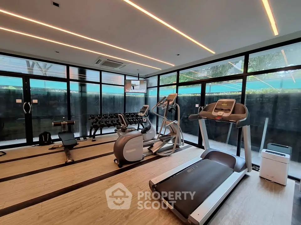 Modern gym with state-of-the-art equipment and large windows for natural light.