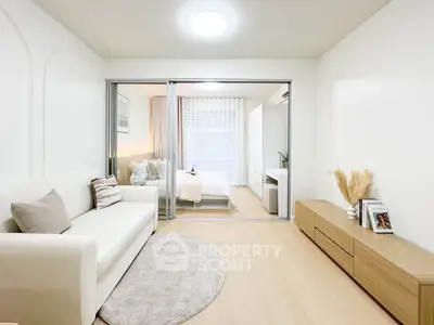 Modern open-plan living room with cozy bedroom, stylish decor, and natural light.