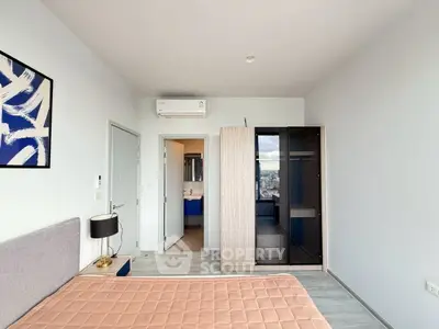Modern bedroom with stylish decor and city view, featuring a sleek wardrobe and air conditioning.
