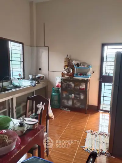Cozy kitchen with tiled floor and ample natural light, featuring a gas stove and storage space.