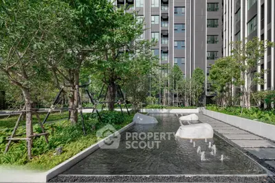 Modern apartment building with lush garden and water feature, offering serene urban living.