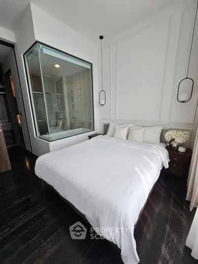 Modern bedroom with glass-walled ensuite bathroom and elegant decor