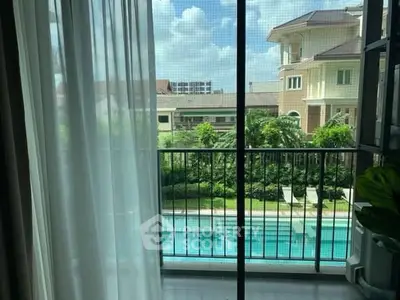 Stunning view from balcony overlooking pool and lush greenery in luxury property.