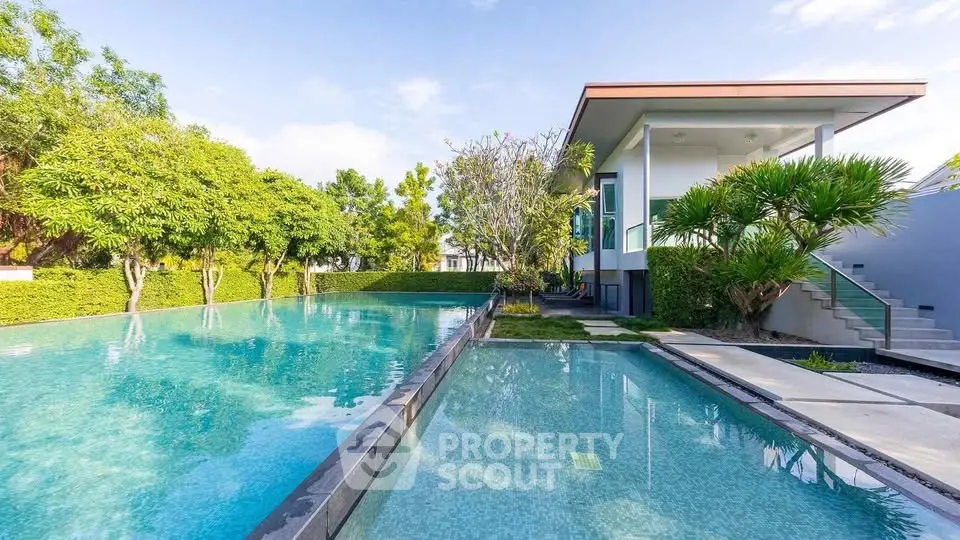 Luxurious modern villa with stunning pool and lush greenery, perfect for relaxation and entertainment.