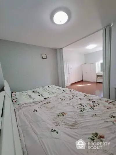 Cozy bedroom with floral bedding and ample natural light