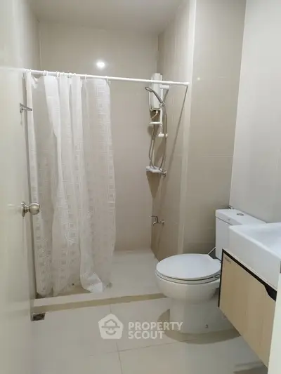 Modern bathroom with shower curtain and sleek fixtures in a contemporary apartment.