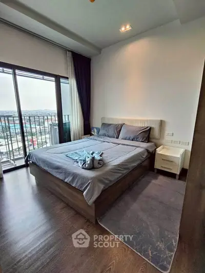 Modern bedroom with large window and balcony view in a stylish apartment.