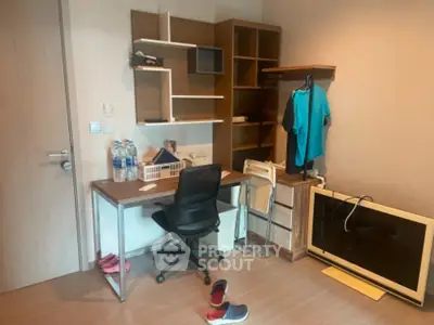 Modern study room with desk, chair, and shelving in a cozy apartment setting.
