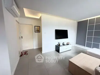 Modern living room with sleek design and wall-mounted TV in a stylish apartment.