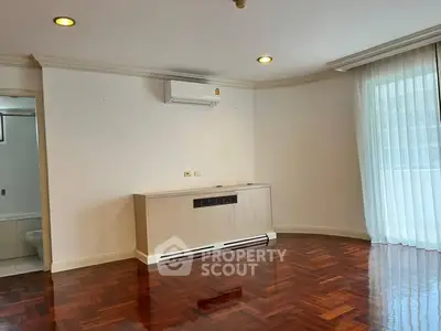 Spacious living room with hardwood floors and natural light