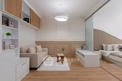 Modern living room with cozy sofa and stylish decor adjacent to a bedroom