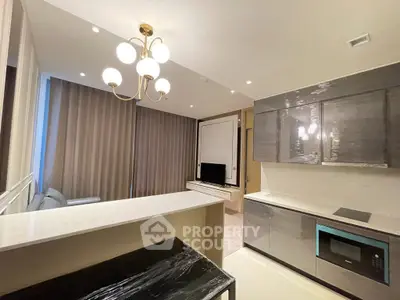 Modern kitchen with sleek cabinetry and elegant lighting in a contemporary apartment.