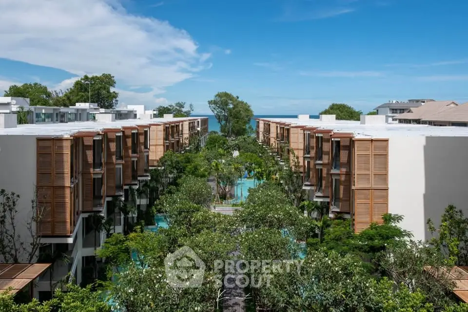Luxurious beachfront apartment complex with lush greenery and stunning ocean views.