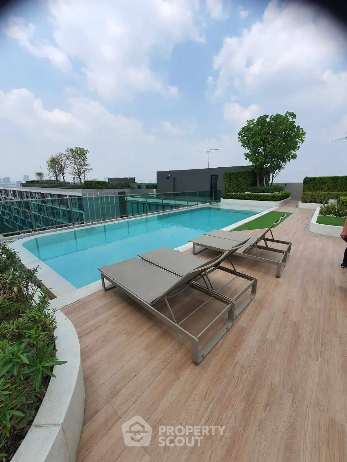 Luxurious rooftop pool with modern lounge chairs and stunning city views.