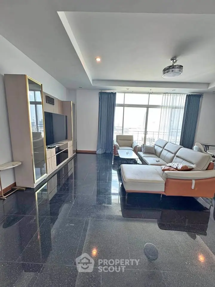 Spacious living room with modern furniture and large windows offering natural light.