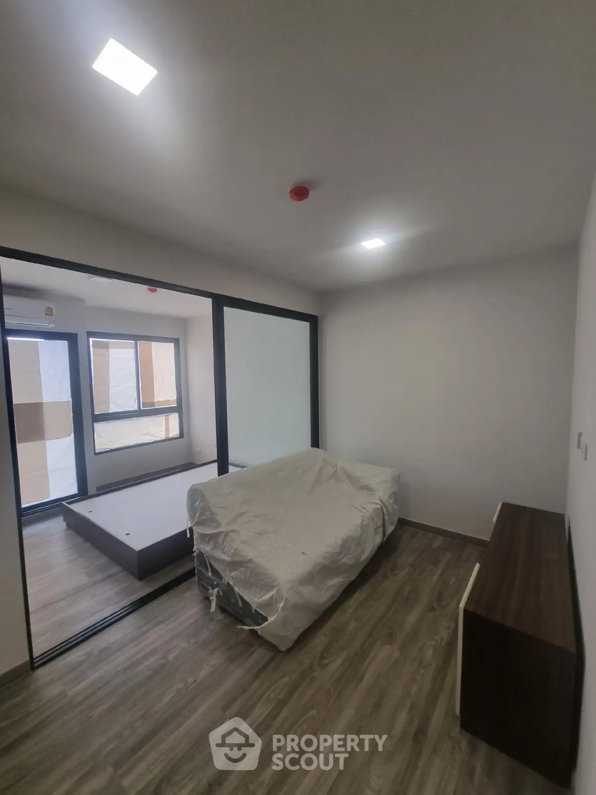 Modern unfurnished apartment with sliding glass doors and wood flooring