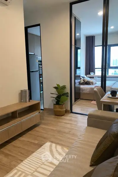 Modern apartment interior with cozy living room and stylish bedroom, featuring wooden flooring and elegant decor.