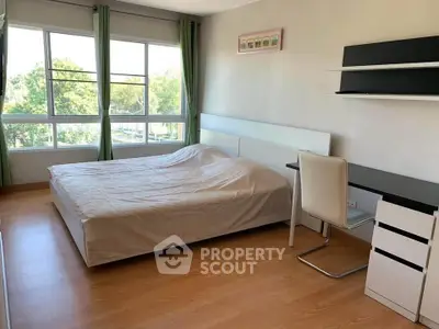 Spacious bedroom with large windows and modern furnishings