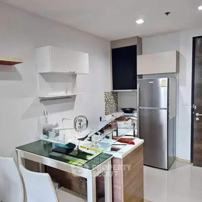 Modern kitchen with sleek appliances and stylish dining area in a contemporary apartment.