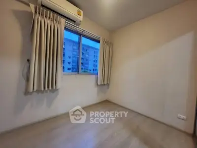 Cozy unfurnished bedroom with air conditioning and window view in modern apartment.