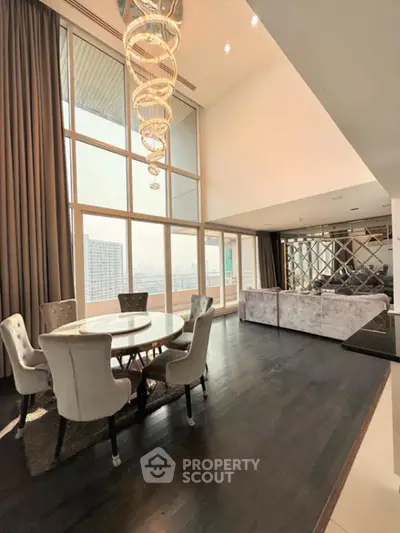 Luxurious high-ceiling living room with elegant chandelier and panoramic city view