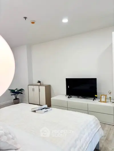 Modern bedroom with stylish decor and flat-screen TV, perfect for relaxation and comfort.