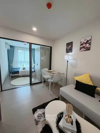 Modern living room with glass partition and cozy bedroom view