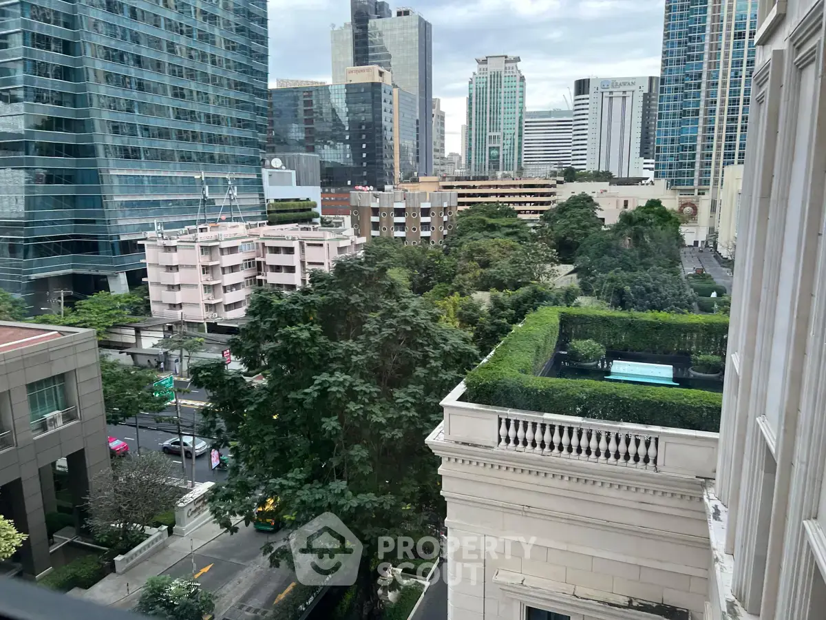 Stunning urban view from high-rise building with lush greenery and city skyline.