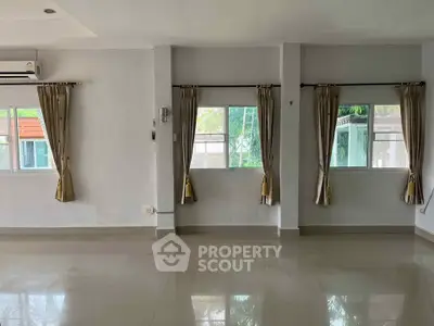 Spacious empty room with large windows and glossy tiled floor, ideal for customization.