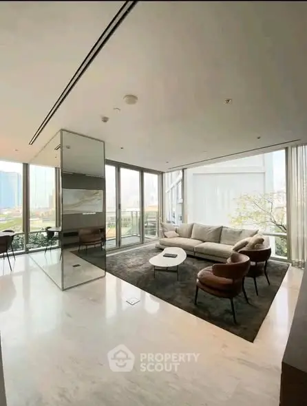 Luxurious modern living room with floor-to-ceiling windows and elegant furnishings.