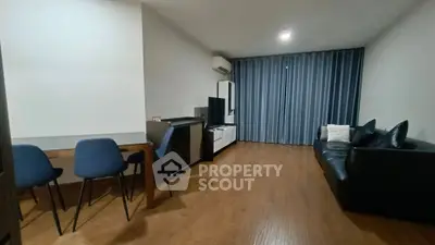 Spacious living room with modern furniture and wooden flooring, perfect for relaxation and entertainment.