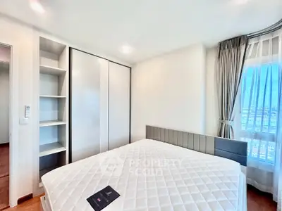 Spacious bedroom with large window and modern closet in a bright apartment.