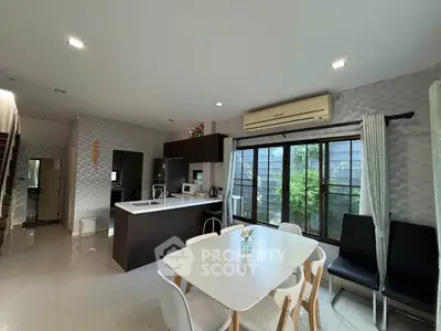 Modern open-layout kitchen and dining area with natural light and stylish decor.