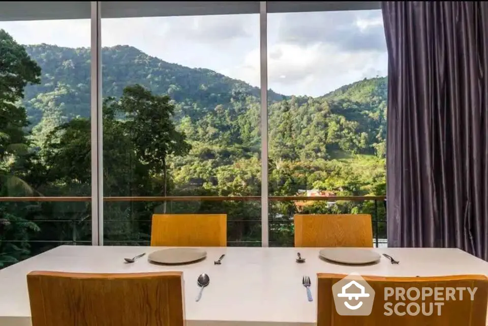 Stunning dining area with panoramic mountain views through large windows.