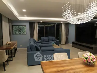 Luxurious modern living room with elegant chandelier and plush blue sofas