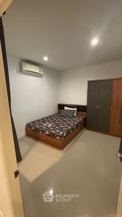 Cozy bedroom with modern furnishings and air conditioning unit.