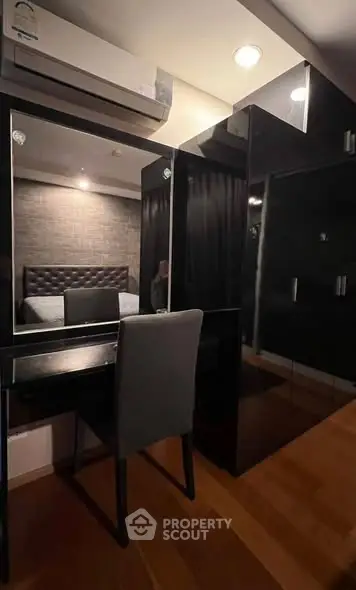 Modern bedroom with sleek black furniture and cozy lighting