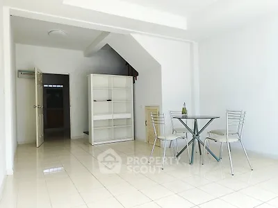 Spacious minimalist living area with glass dining table and modern chairs