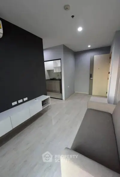 Modern living room with sleek design and open kitchen layout in a stylish apartment.