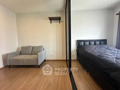 Modern bedroom with sleek design, featuring a cozy bed and stylish sofa, perfect for comfort and relaxation.