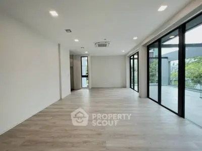 Spacious modern living room with large windows and balcony access