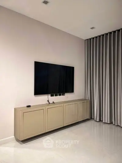 Modern living room with sleek TV setup and elegant curtains