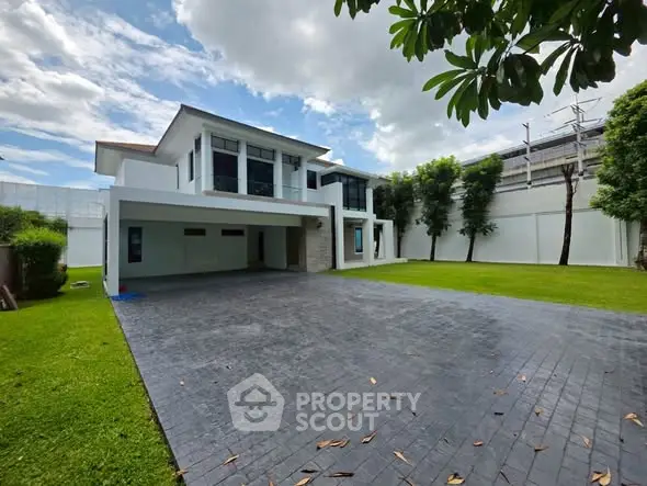 Modern two-story house with spacious driveway and lush green lawn