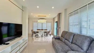 Modern living room with sleek design, featuring a cozy sofa and elegant dining area.
